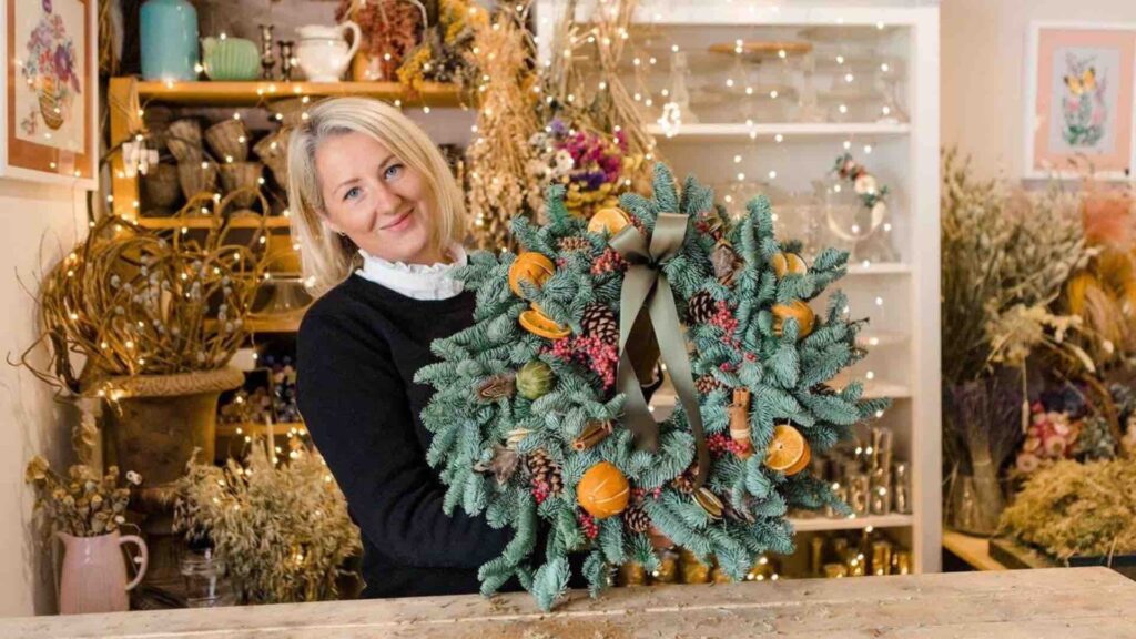Florist holding finished Christmas wreath
