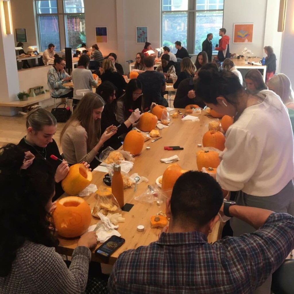 People sitting at table and carving pumpkins