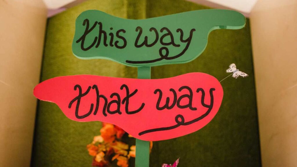 Alice In Wonderland style 'This Way, That Way' green and pink sign prop.