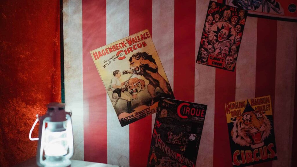 Circus posters on red and white circus backdrop.