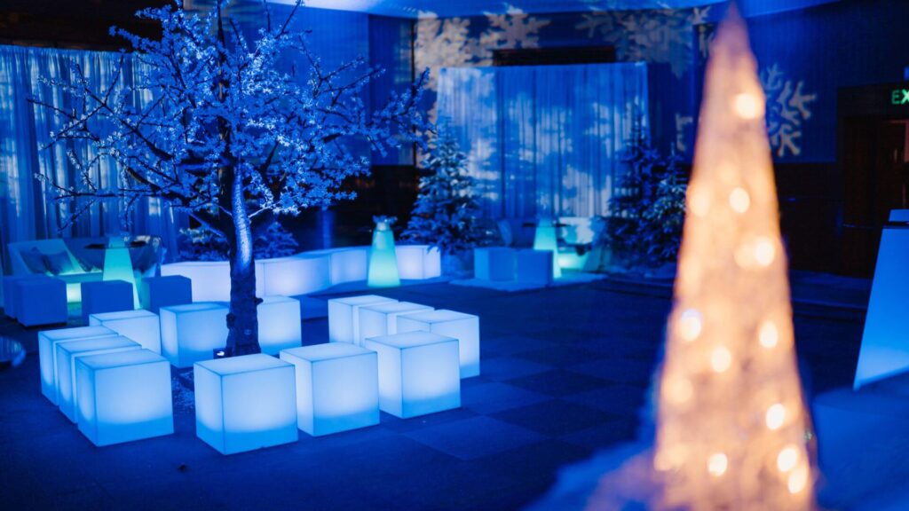 Winter Wonderland Event space with LED seat cubes, tree props and lighting.