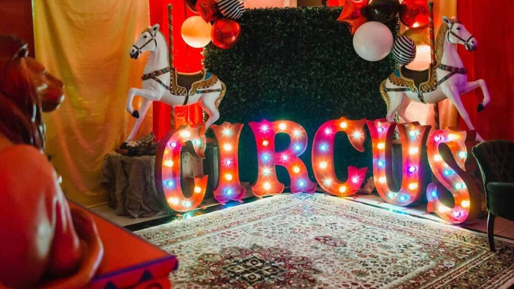 Vintage circus themed event space with large letter props, carousel props and rug.