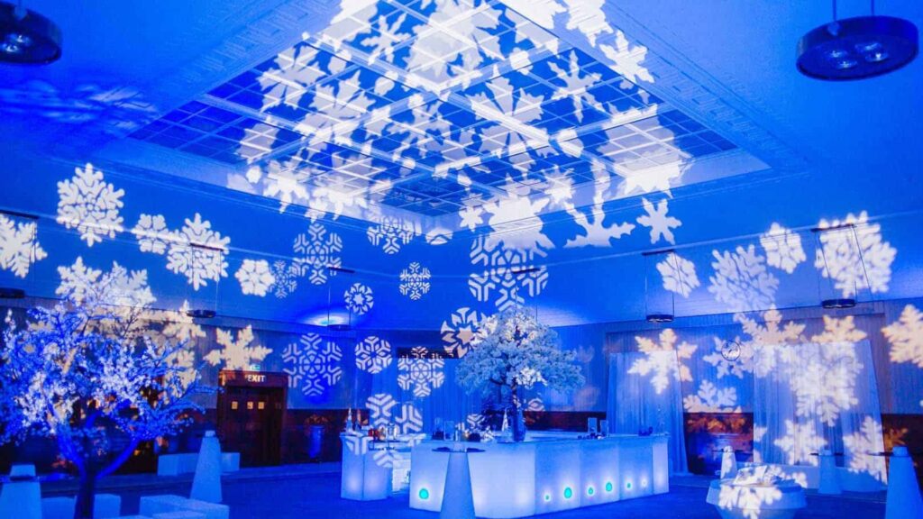 Winter Wonderland Themed Event space with ice bar, standing tables and bright white light projections.