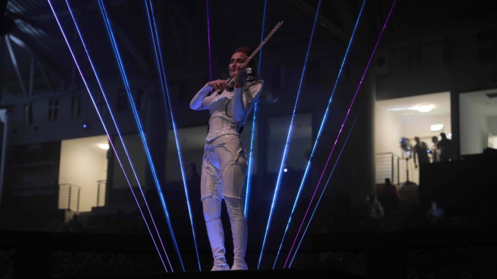 Violin player plays violin surrounded by lasers