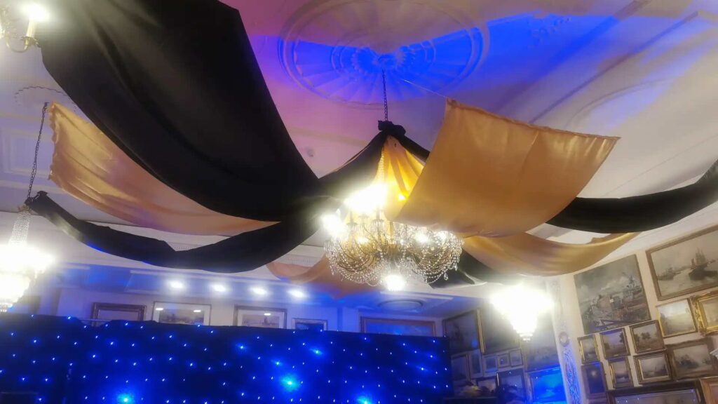 Black and gold ceiling draping used for transforming ceilings and lighting at venues.