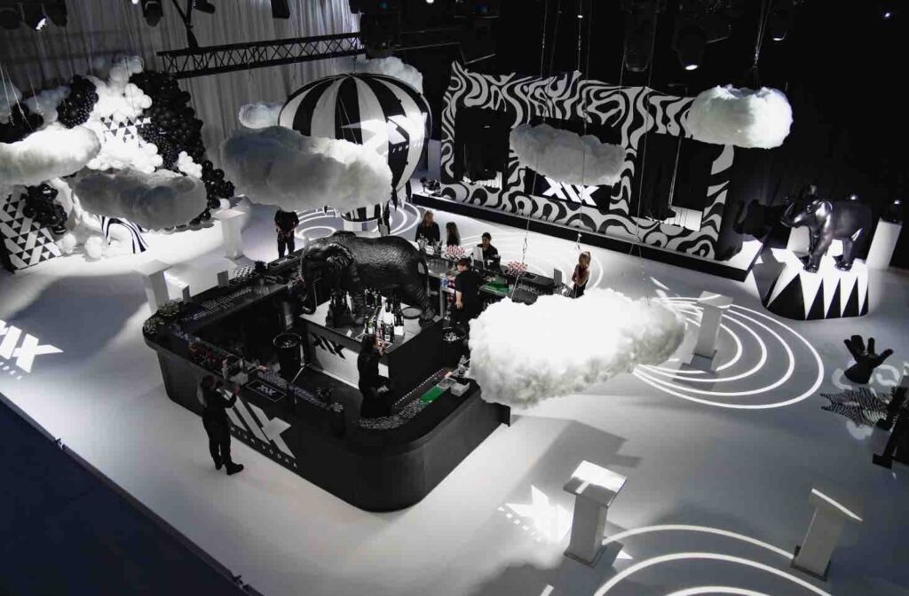 Aerial view of event space with floating balloon bar, lighting projections, standing tables and stage.