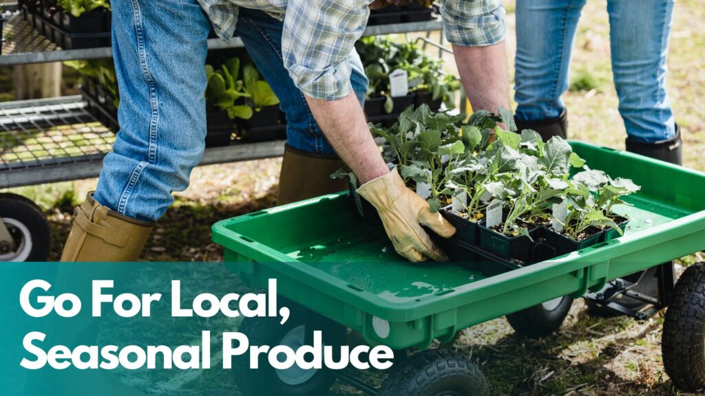 Farmer picking produce up and putting it into green wheelbarrow.