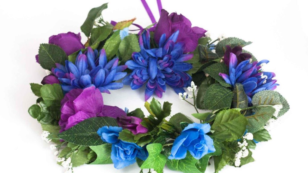 A flower crown is created with faux purple and blue flowers
