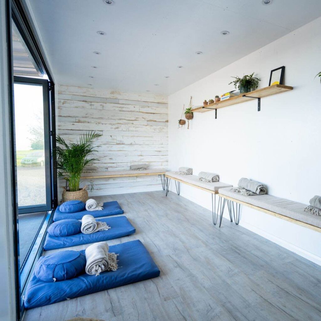 A cosy zen like white space with meditation beds and wooden interior ideal for corporate summer events.