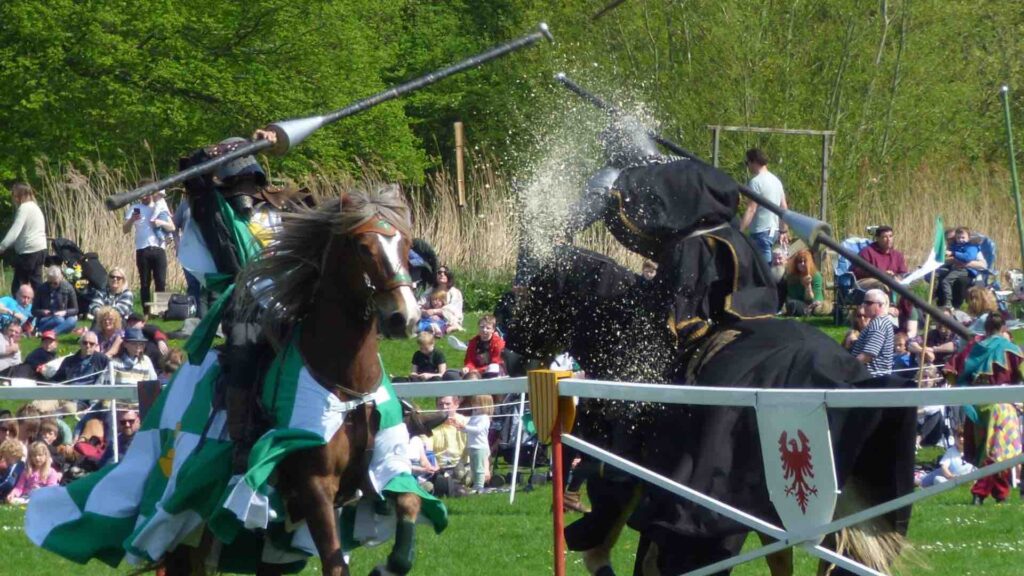 Two jousting knights knock each other off their horses