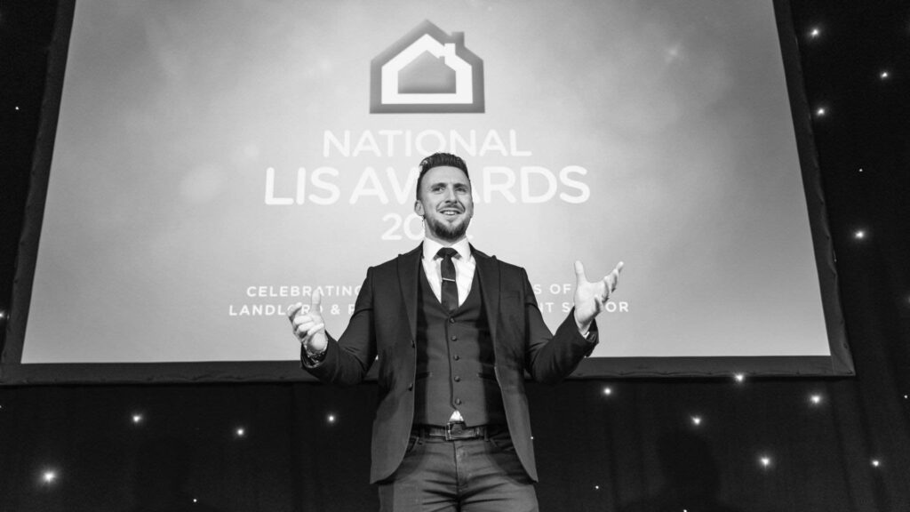 A corporate magician stands on stage giving a presentation