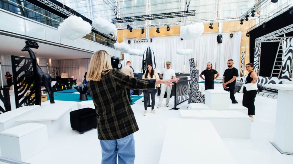 Event manager stood in event space directing colleagues. Offered as part of our event management agency services.
