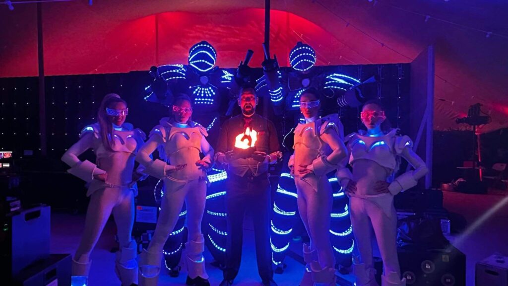 LED glow bots standing alongside the glow girls at a corporate event at Magna Carta Island, London.