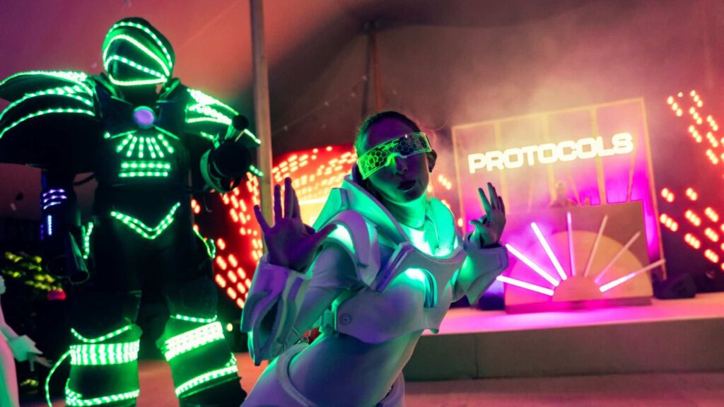 Glow girl LED dancer smiling and waving at protocols event in London.