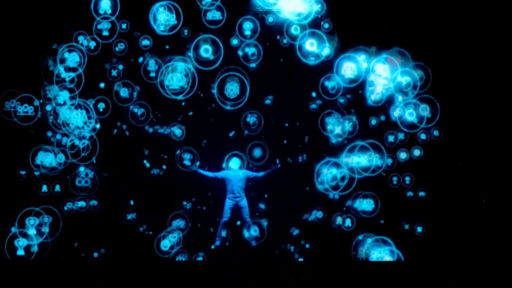 A projection of a blue figure amongst blue bubbles on a dark screen