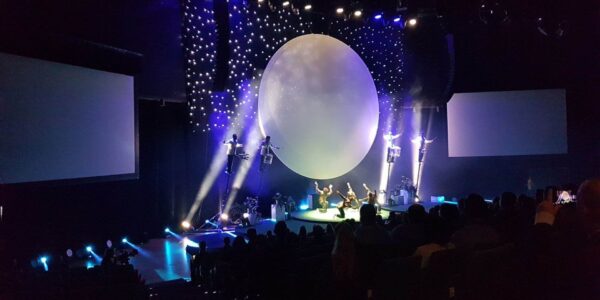 Stunning full scale sky drummer on stage with lights and projection for a production