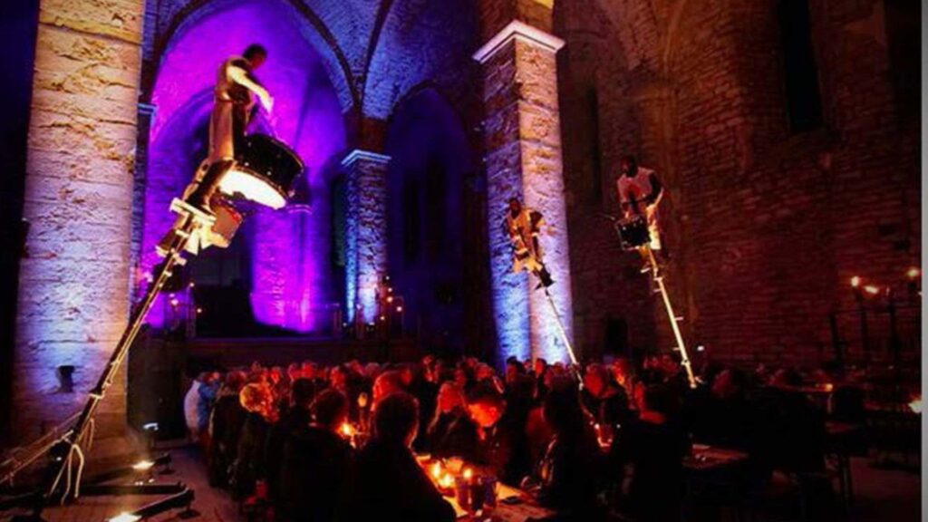 Aerial drum show featuring drummers on angled poles