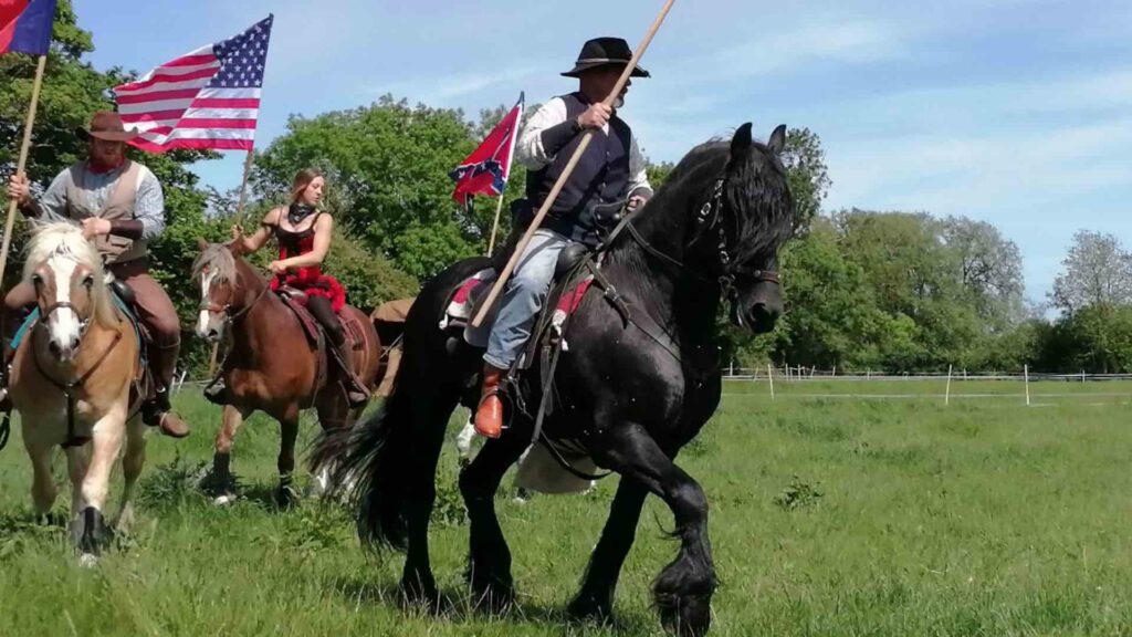 A beautiful black horse is ridden by a wild west stunt performer