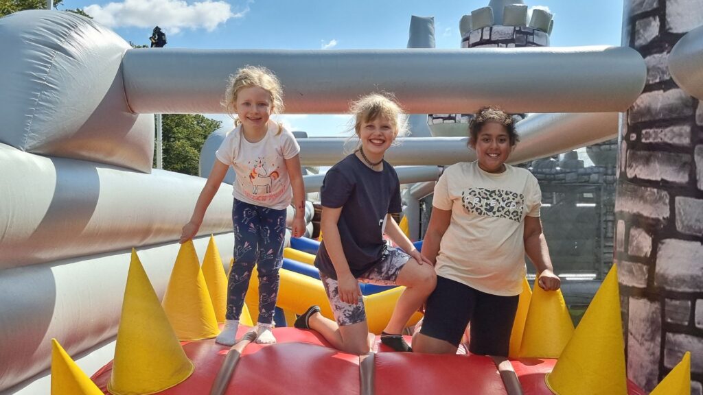 Three children on a themed inflatable obstacle course.