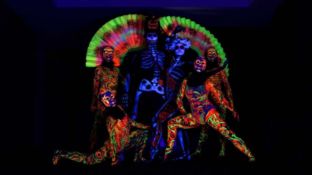 Dancers painted in UV paint for day of the dead themed dance performance for Halloween show hire for events