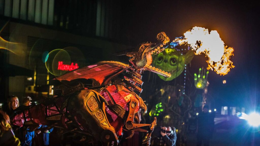 A walkabout dragon puppet in a steampunk style breathing fire
