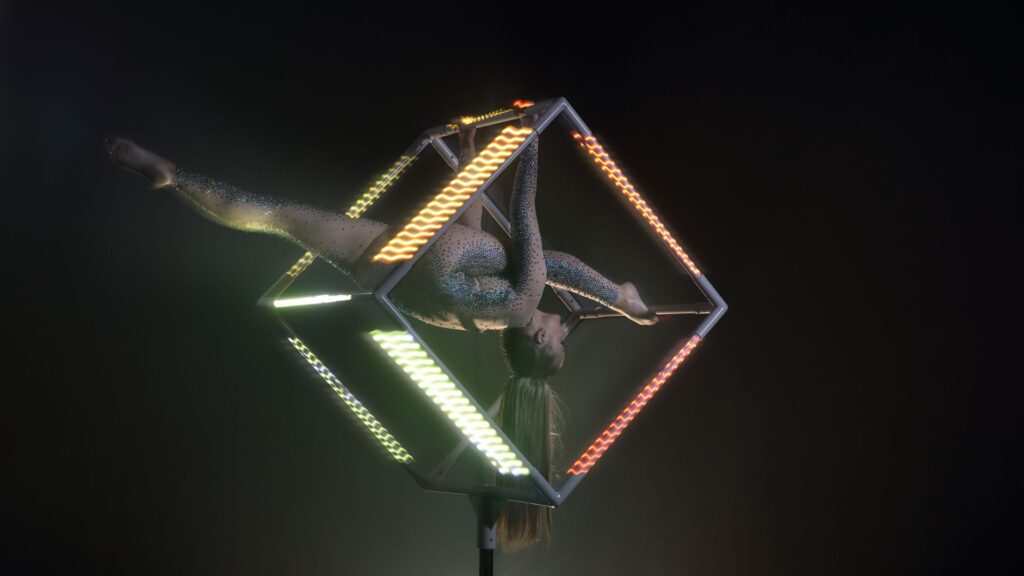 An LED aerial cube performer performing acrobats