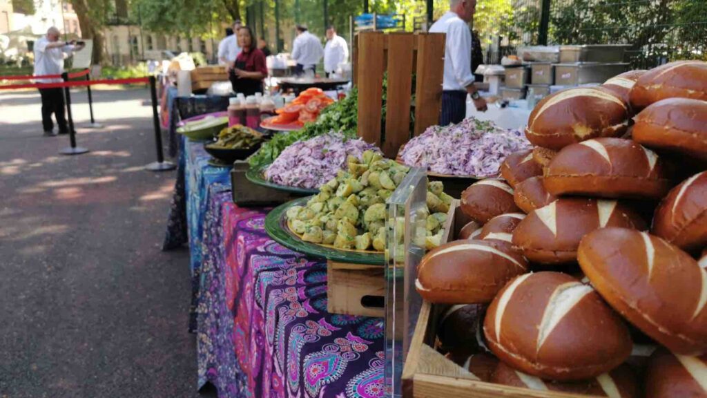 Colourful cold food including salads, bread rolls, condiments, meats and more laid out for guests to help themselves to at corporate fun day event.