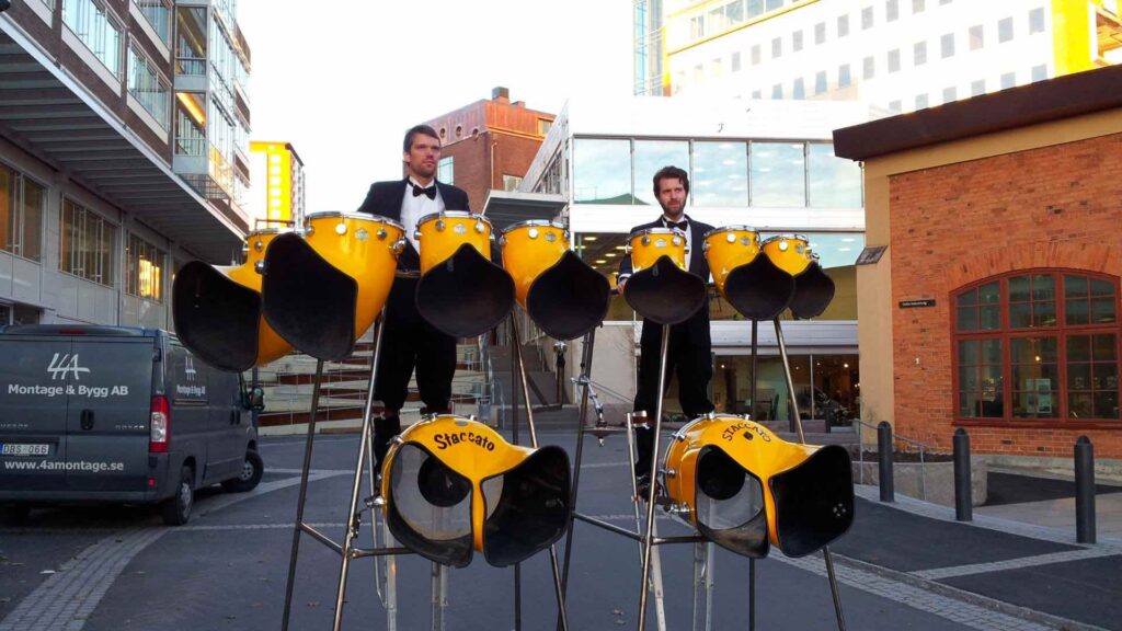 Colorfully dressed performers on stilts showcasing their percussion skills, adding rhythm and excitement to the event.
