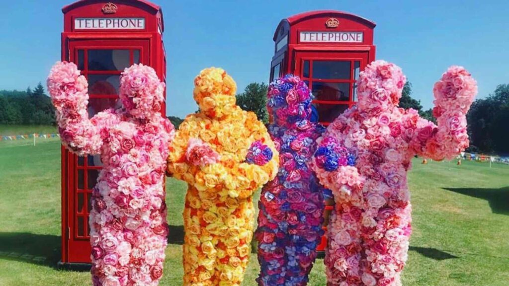 Walkabout flower people posing in front of phone boxes
