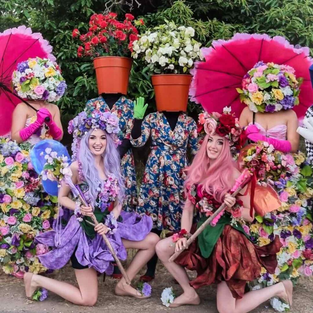 A group of woodland fairies dressed as enchanted characters in bold outfits