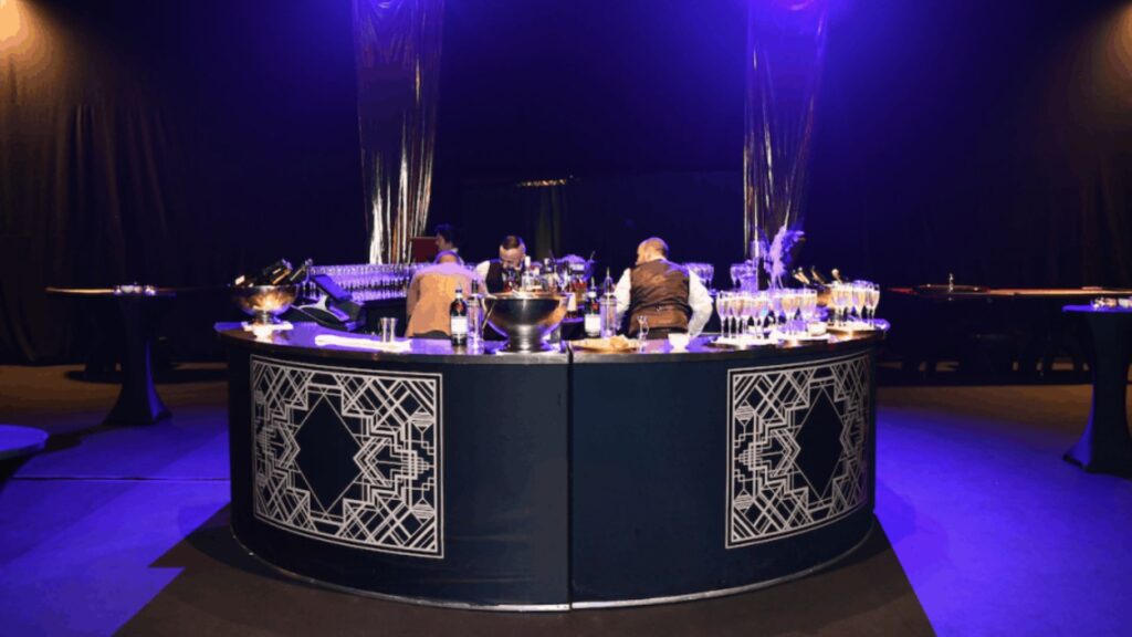 1920s themed event bar with two bartenders making drinks.