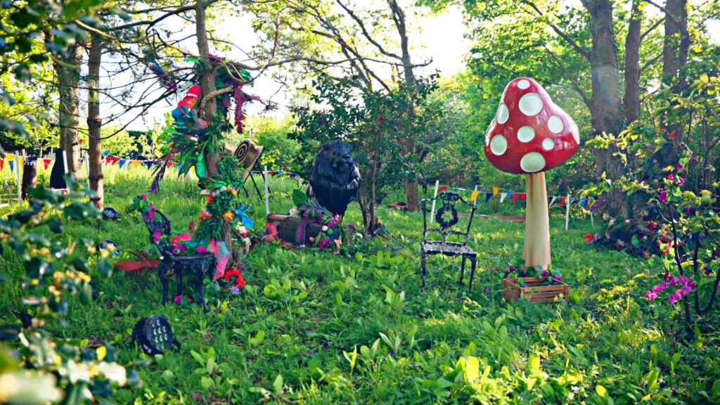 A whimsical outside enchanted garden forest theme set up, featuring a delightful array of flowers, animals, toadstools, and props
