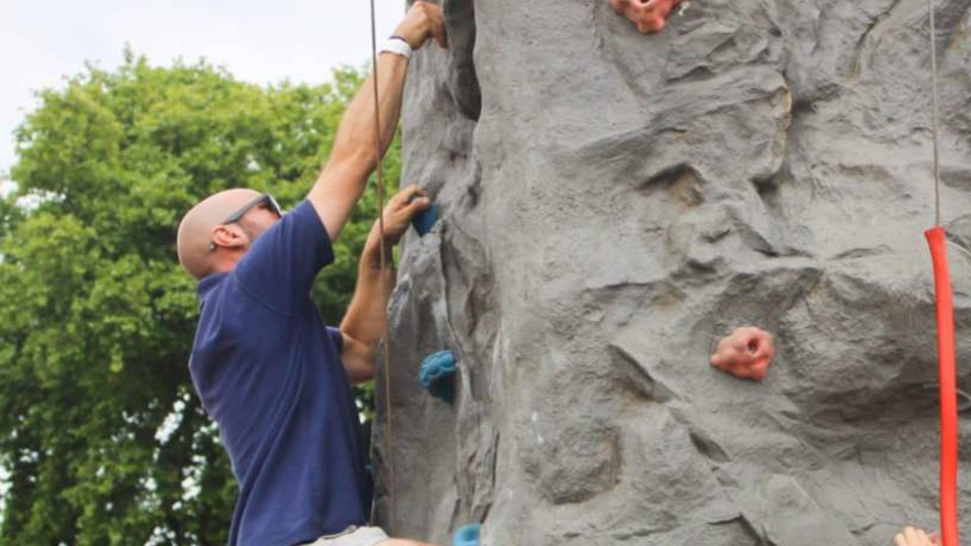 A man climbs a portable rock climbing wall