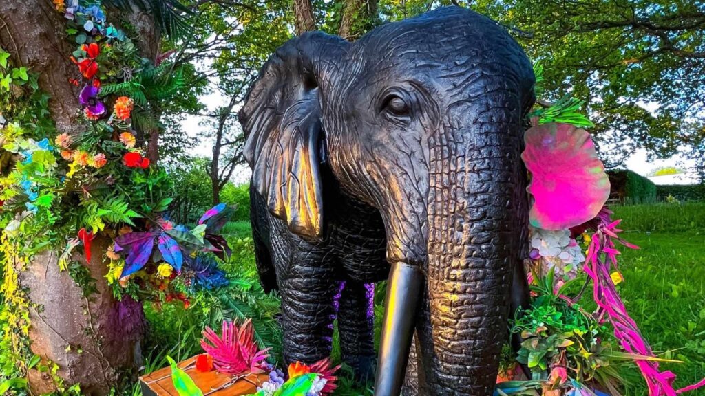 A close up of a giant elephant prop covered in bold bloom props