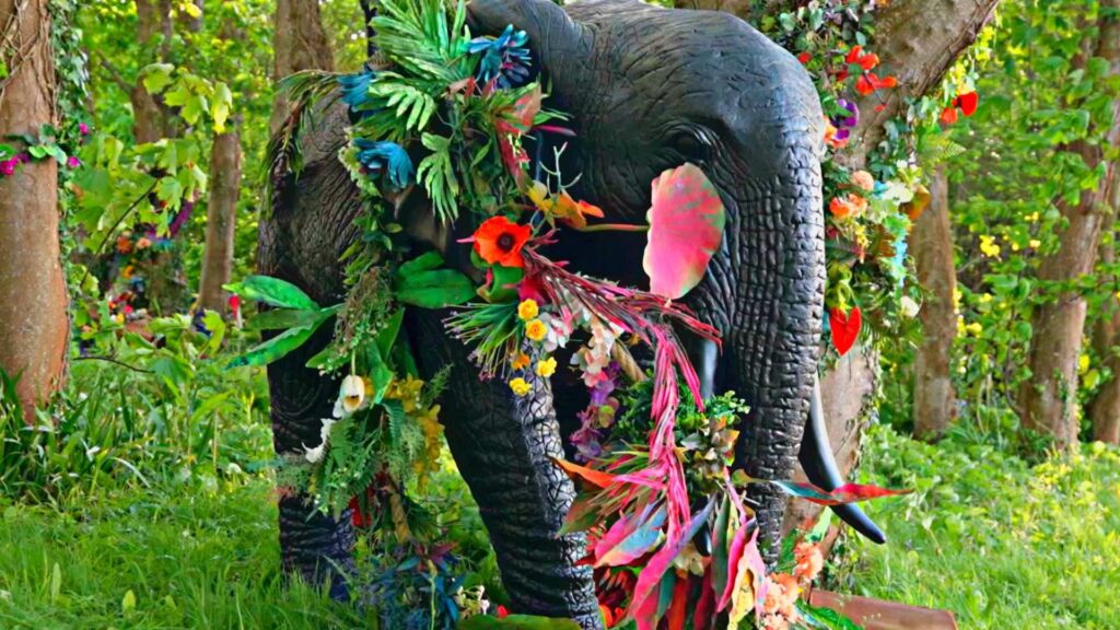A stunning life-size elephant prop covered in pink bold blooms and green foliage