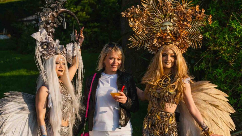 Two celestial inspired costumed ladies in gold and silver walking with a guest
