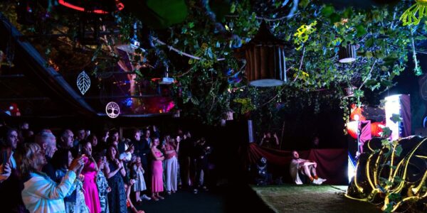 Guests enjoying evening entertainment on our tailored garden theme set design inside our marquee enchanted forest theme party