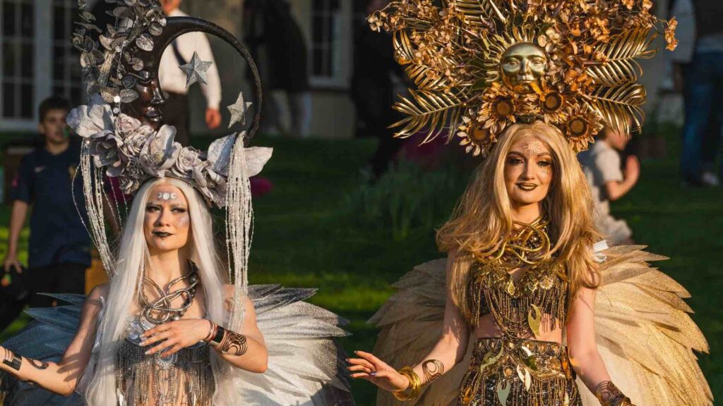 A duo of fairytale walkabout goddesses with beautiful reflective headwear and gold and silver costumes