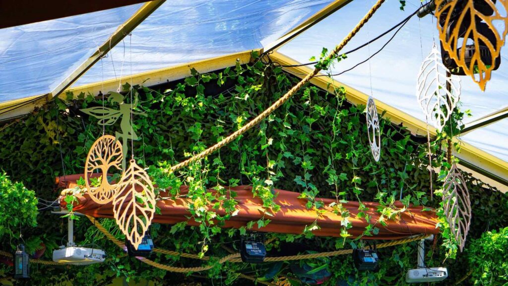 A carefully orchestrated arrangement of lush green foliage and and dangling copper and gold themed garden inspired decor