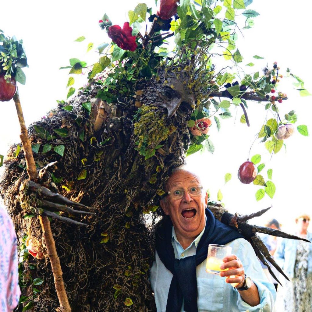 A man regails in joy with a towering enchanted real life tree stilt walker