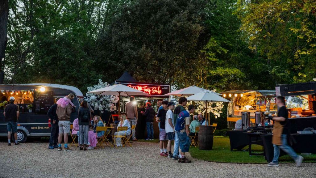 Mobile catering stands serving pizza, lobster, burgers and more at an outdoor event.