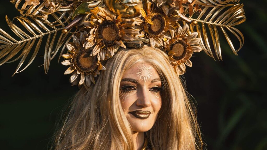 A golden themed goddess who poses as living statue and walkabout at spring and summer themed garden parties and festivals