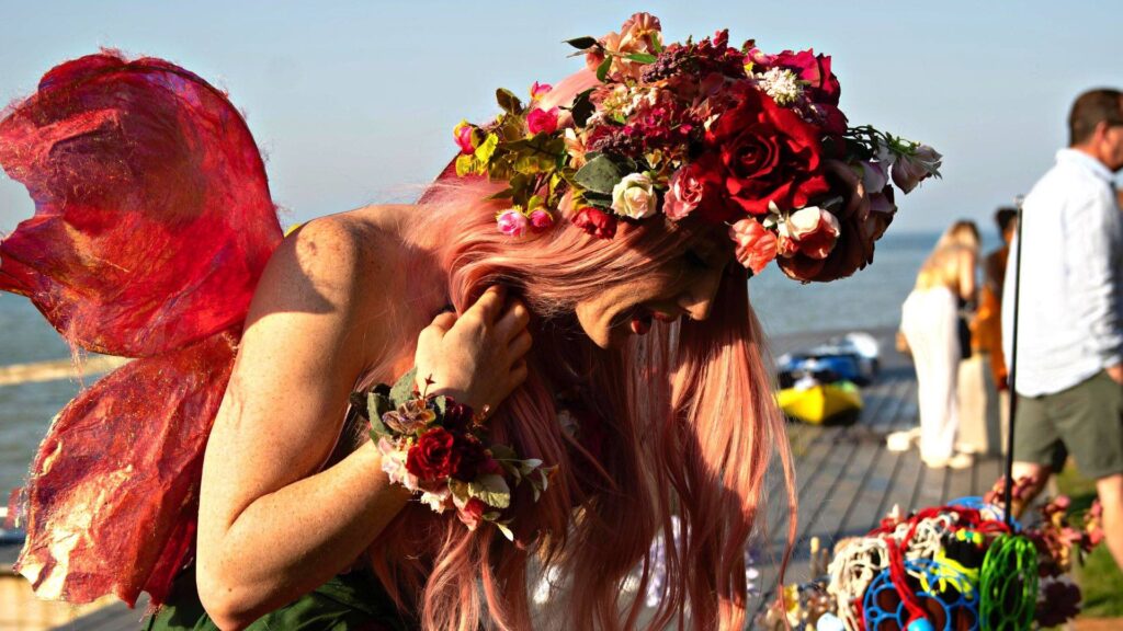 A beautifully costumed enchanted fairy in pink dress and flower boom head wear
