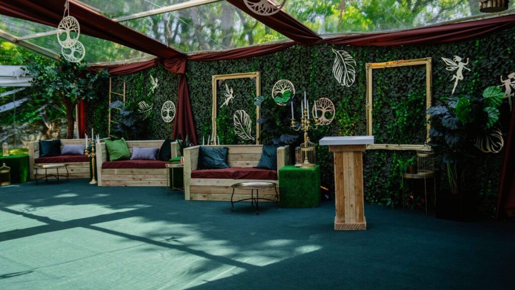 A set design featuring palette furniture and gold props for an enchanted garden theme party