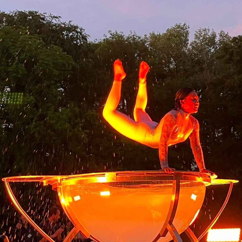 A female performs acrobats on a large water bowl apparatus in Amsterdam