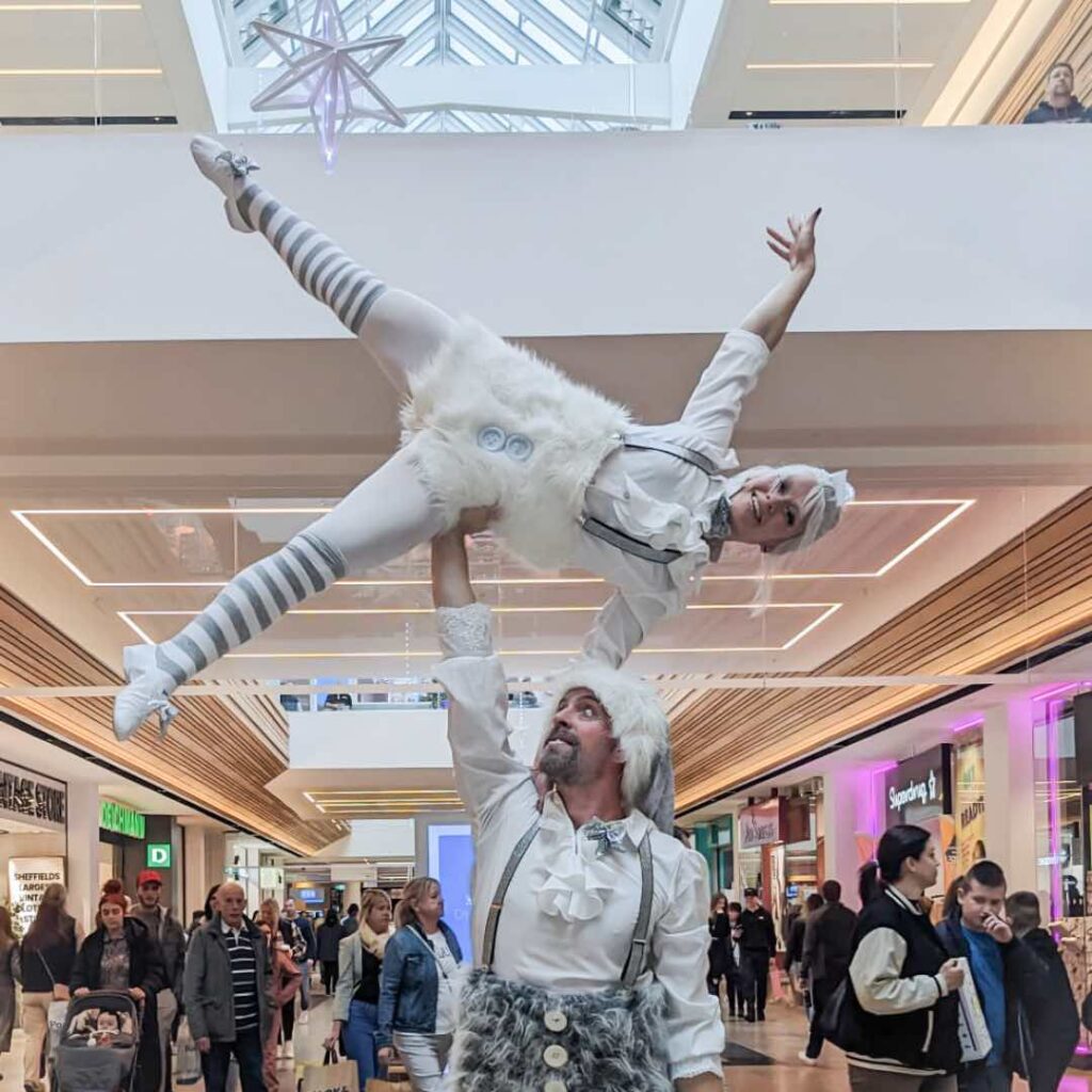 Ice themed elf acrobats performing hand balance stunt