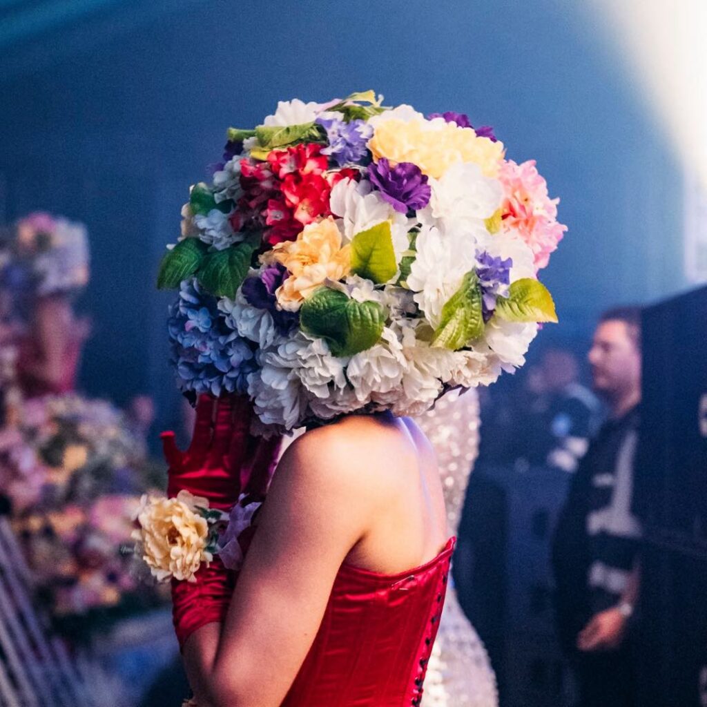 A flower head performer meeting guests at a corporate event