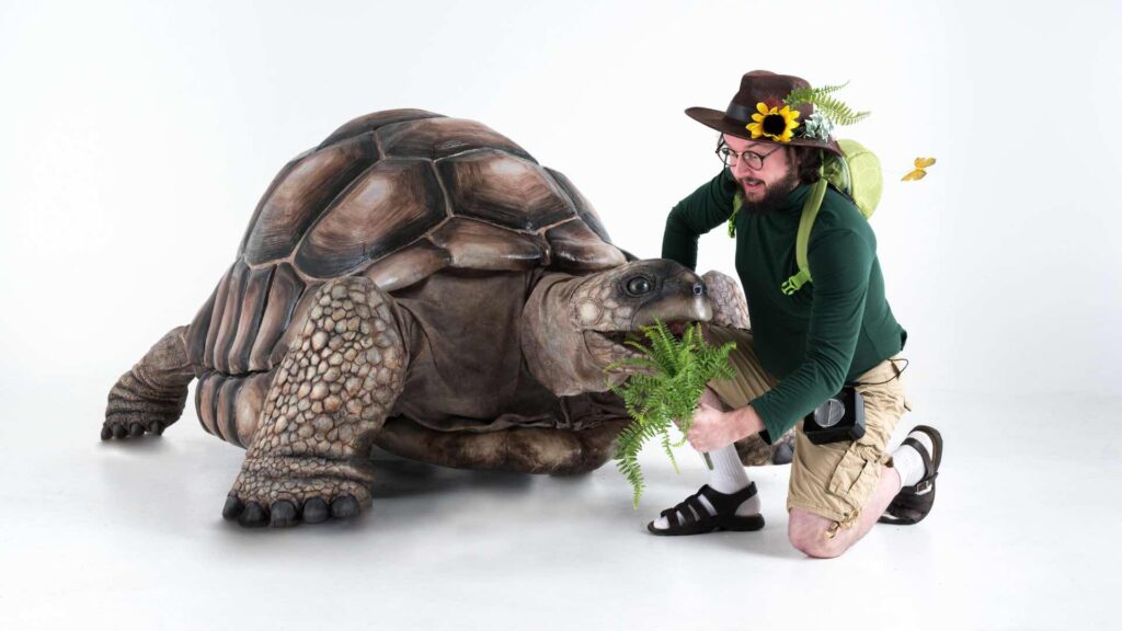An animatronic tortoise walking around and engaging with people, imitating lifelike movements.
