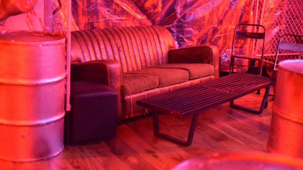 Vintage-style seating area in 'Slaughterhouse' room at Halloween mansion party.