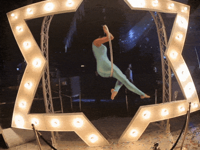 Star aerialist hanging on a hoop design with LED glowing frame.